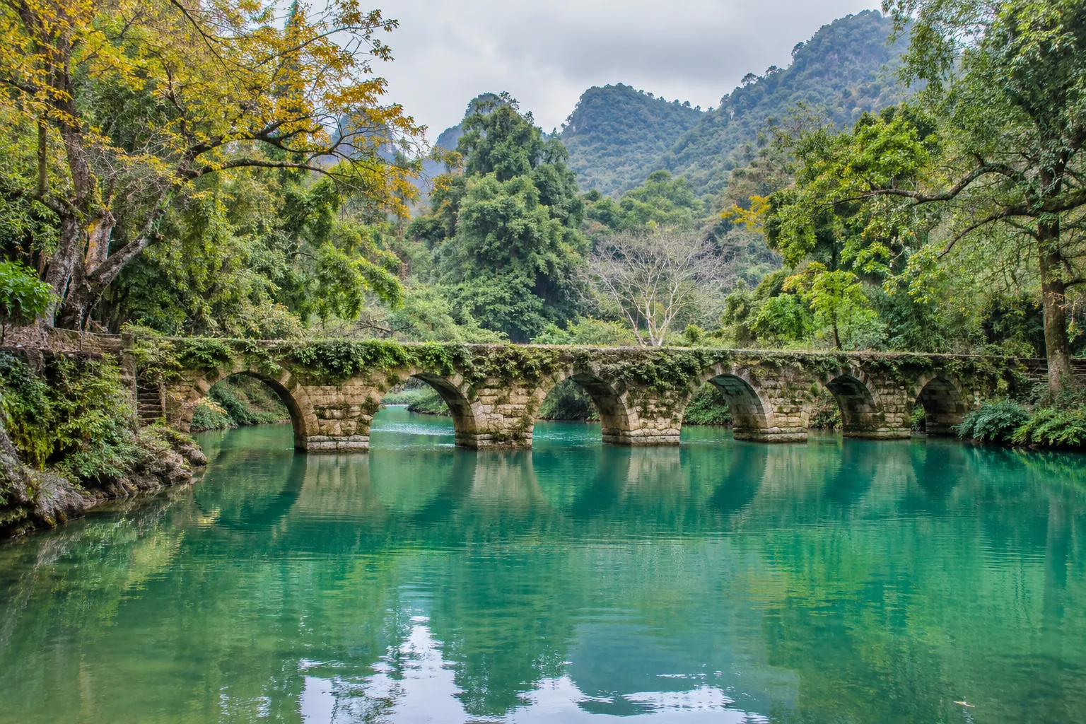An old bridge, a valley of turquoise water · thematic illustration