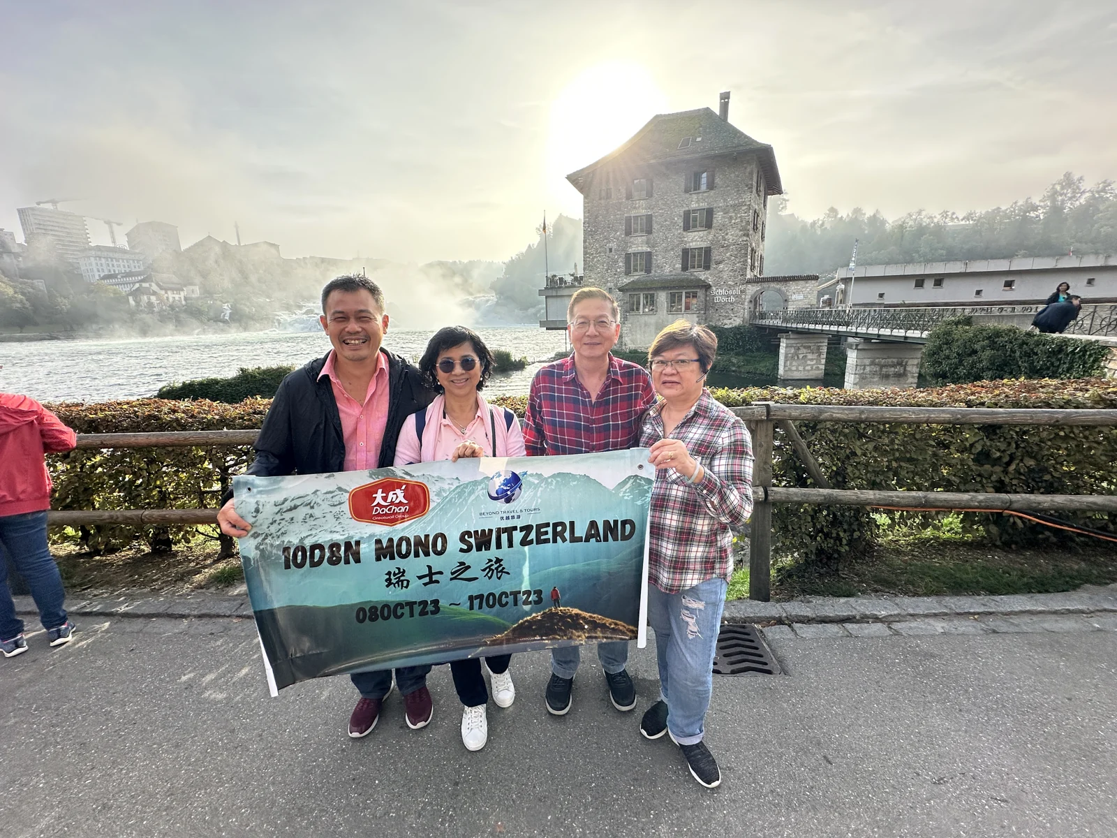 Travellers posing in front of Rhine Falls in Switzerland