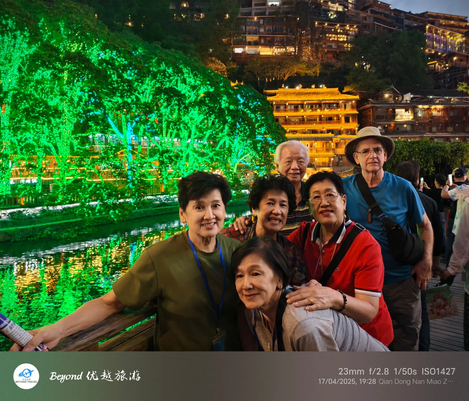 A small group of travellers posing at night