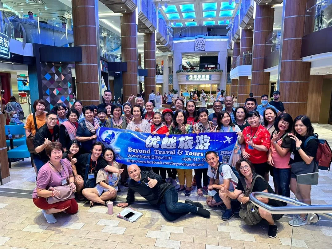 Travellers holding the Beyond Travel tour flag indoors
