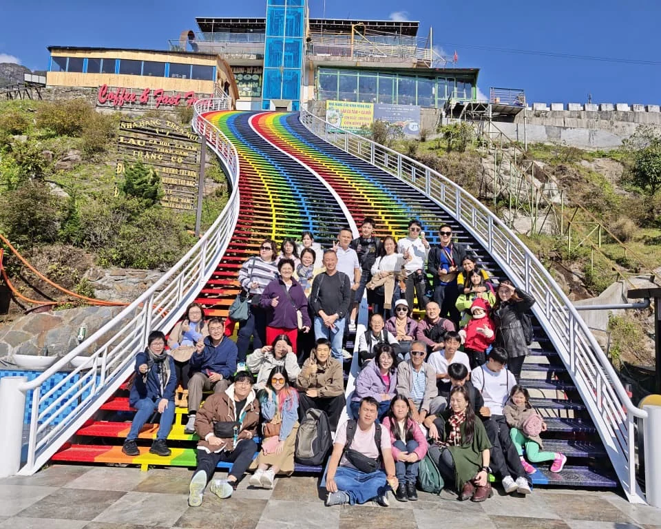 Travellers posing on colourful rainbow steps